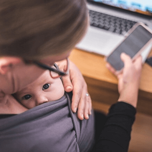 Como lidiar con la culpa parental madre trabajando con su hijo en brazos