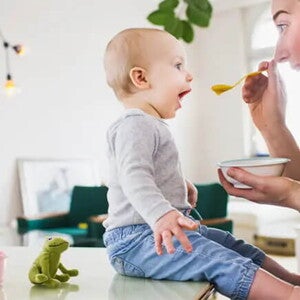 Conoce el desarrollo de tu bebé de 10 meses. Bebé de 10 meses sentado comiendo con mamá