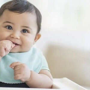 Conoce el desarrollo de tu bebé de 9 meses. Bebé de 9 meses sentado sonriendo.