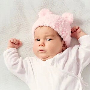 Bebé de dos meses acostada sobre la cama.