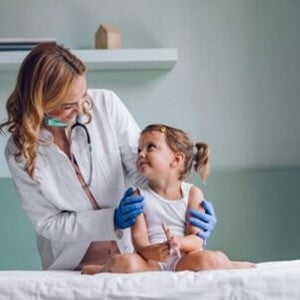Conoce qué es la escarlatina Doctora revisando al bebé con escarlatina