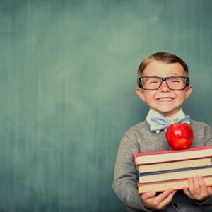 Conoce qué son las estrategias de aprendizaje. Niño sonriendo con libros en la mano.