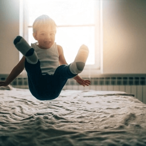 Estimulación temprana para bebés y niños niño saltando sobre la cama