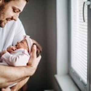 Los granitos en la cara de los bebés es un fenómeno común Papá alzando su bebé y revisando los granito de su cara