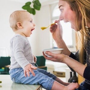 Conoce por qué son tan importantes los probióticos saludables en los niños. Mamá alimentando a su hijo con una papilla.