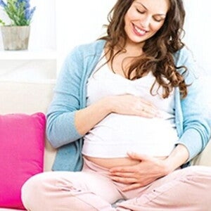 Imagen de una madre soltera cariñosamente tocando su barriga durante el embarazo Imagen de una madre soltera cariñosamente tocando su barriga durante el embarazo