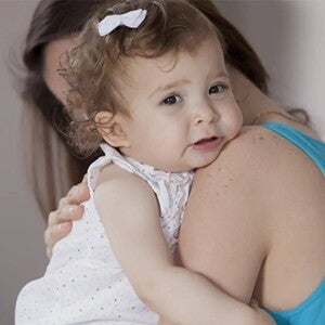 Síntomas de apendicitis Mamá abrazando a niña pequeña que llora