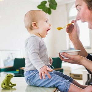 ¿Qué son los probióticos? Mamá alimentando con una cuchara a su hijo pequeño con probióticos