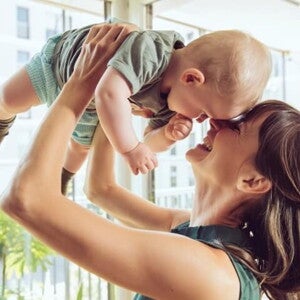 Conoce que es la curva de crecimiento y desarrollo. Mamá cargando a su bebé.
