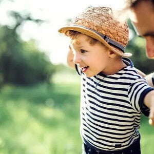 Conoce qué es la motricidad gruesa y cuáles son sus beneficios. Niño haciendo equilibrio con su padre.