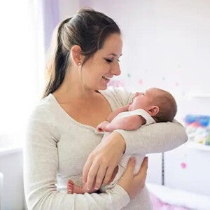 Conoce todo lo que debes saber si eres mamá primeriza. Mamá primeriza alzando en brazos a su bebé recién nacido.