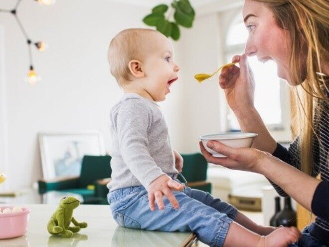 Conoce por qué son tan importantes los probióticos saludables en los niños. Mamá alimentando a su hijo con una papilla.