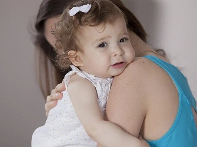 Mamá abrazando a niña pequeña que llora