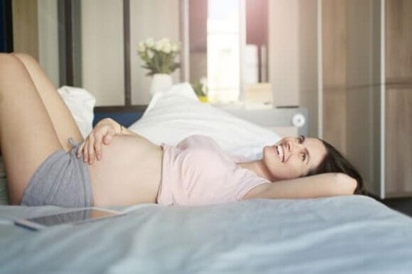 El tamaño y color del pezón son algunos de los cambios Mujer embarazada recostada en la cama