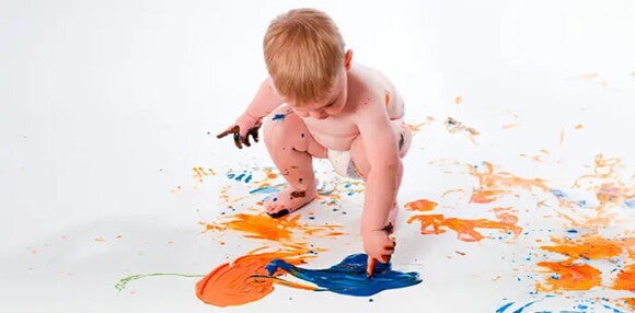 Los juegos y actividades estimulan a tu bebé de 18 meses. Bebé de 18 meses jugando con pinturas