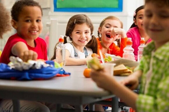 Conoce la importancia de los probióticos saludables para la flora intestinal. Niños comiendo en la mesa los probióticos saludables.