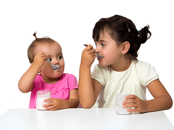Bebé y niña pequeña comiendo un snack.