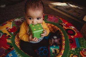 El juego estimula el desarrollo de tu bebé de 7 meses Bebé de 7 meses sentado jugando con sus juguetes