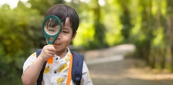 Existen varios tipos de estilos de aprendizaje. Niño con una lupa en la mano.